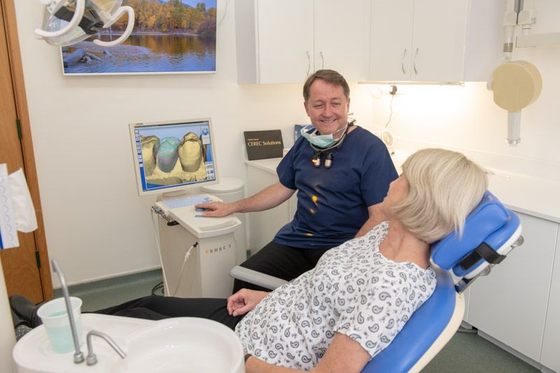 Dentist talking with a patient in the chair at Envisage Dental West Moors